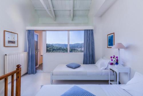 a bedroom with a bed and a window at Villa Pelago in Skopelos Town