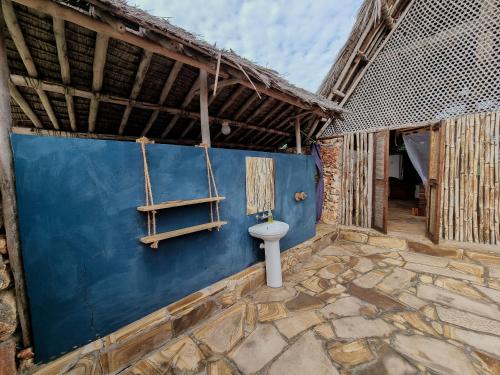 a bathroom with a toilet in the side of a building at Pangani Cliffs Lodge in Pangani