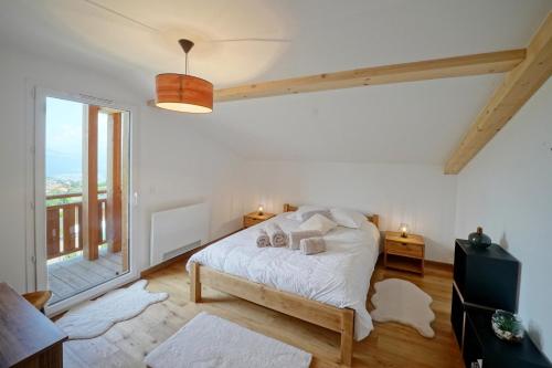 a bedroom with a bed and a large window at Magnifique Chalet neuf 8 pers, 800 m télécabine Princesse Megeve in Combloux