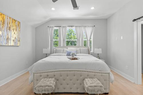 a white bedroom with a large bed and a window at Villa De Briley in Houston