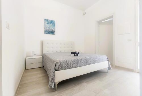 een slaapkamer met een bed in een witte kamer bij Villetta Gioia in Torre Lapillo