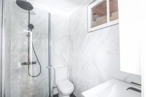 a white bathroom with a shower and a toilet at Casa San Pierro in Corfu