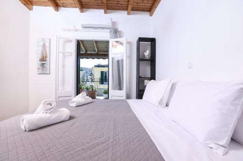 a bedroom with a large white bed with towels on it at Casa San Pierro in Corfu