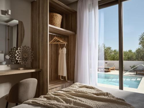 a bedroom with a bed and a view of a pool at Kapodistria Luxury Villas - Serene Escape in a Scenic, Secluded Location, by ZanteWize in Plános
