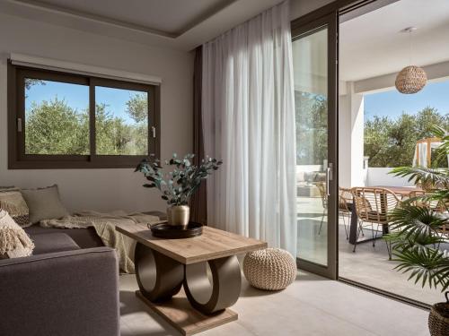a living room with a couch and a table at Kapodistria Luxury Villas - Serene Escape in a Scenic, Secluded Location, by ZanteWize in Plános
