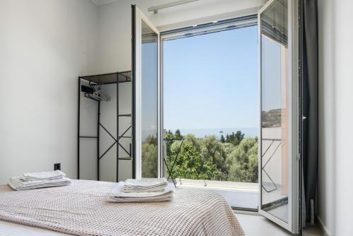 a bedroom with a bed and a large window at Robin's in Lefkada