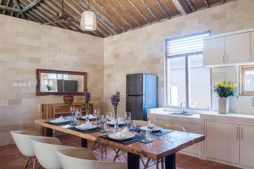 eine Küche mit einem Holztisch mit Stühlen und einem Kühlschrank in der Unterkunft Selog Villa 2 in Seminyak