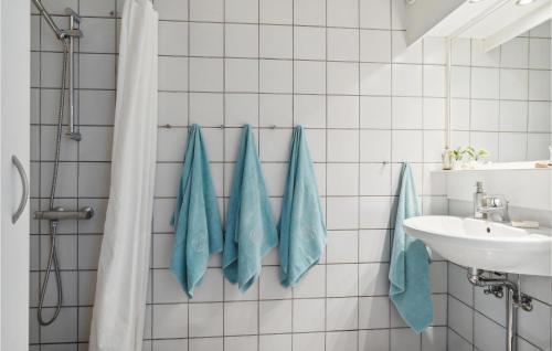 a bathroom with blue towels hanging on the wall at 1 Bedroom Nice Apartment In Risskov in Risskov