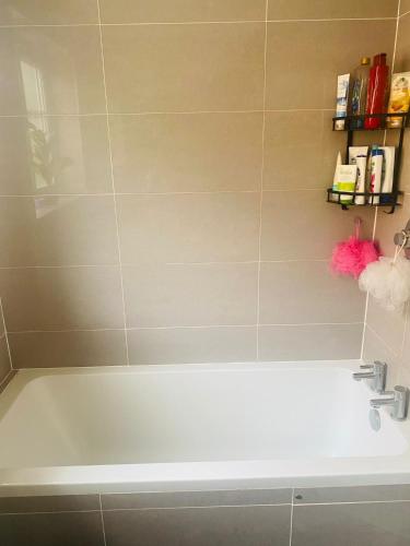 a bath tub in a bathroom with a sink at Private Double Room available in Hampshire in Liphook