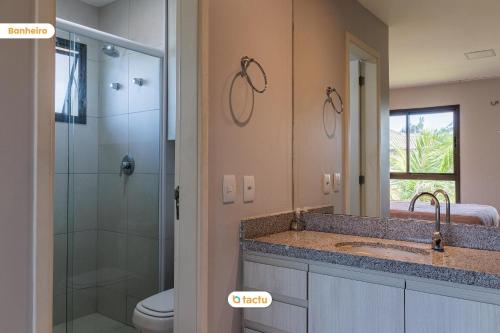 une salle de bain avec un lavabo, une douche et des toilettes dans l'établissement Bungalow face jardin au VG Sun Cumbuco par Tactu, à Paracumbuca