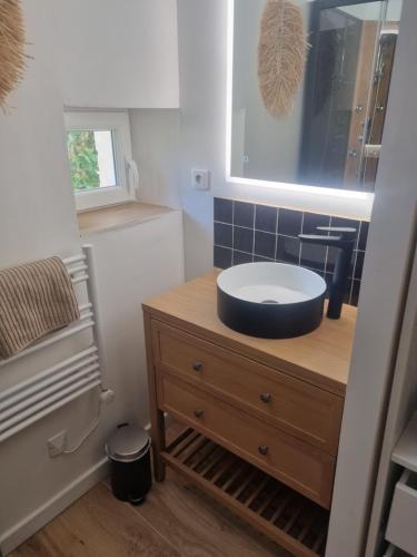 a bathroom with a sink on top of a wooden dresser at ENTRE VENTOUX ET LUBERON Chambre d'hôte in Sault-de-Vaucluse