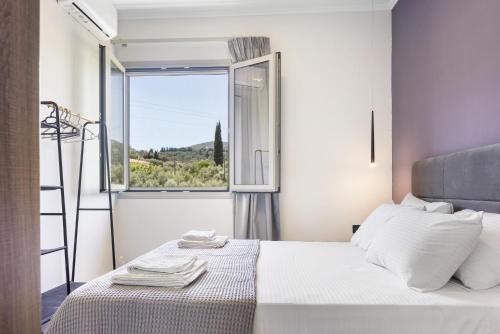 a bedroom with a bed and a large window at Robin's in Lefkada Town