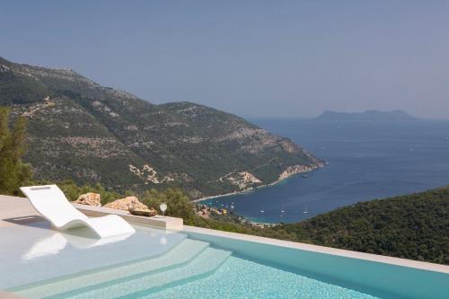 a white chair sitting on top of a swimming pool at Armante Supreme Villas-Villa Nicole in Fternón