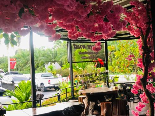 a restaurant with pink flowers hanging from the ceiling at กอบสุข รีสอร์ท2 k12 in Ban Ton Liang