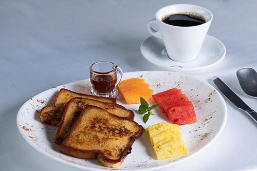 a white plate with toast and a cup of coffee at Suitree Experience Hotel in Guanacaste