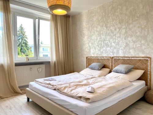 a bedroom with two beds in a room with a window at B10 Apartments Bulvár in Žilina