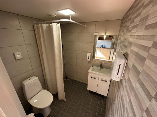 uma casa de banho com um WC, um lavatório e um espelho. em Ratturi talu em Reigi