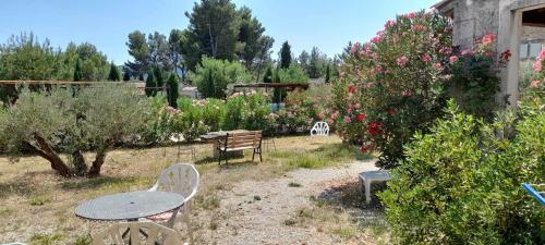 un tavolo e sedie in un giardino fiorito di mas clair de lune a Saint-Rémy-de-Provence