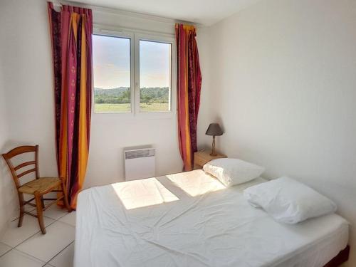 une chambre avec un lit blanc et une fenêtre dans l'établissement Beau pavillon T3 avec terrasse et vue sur la garrigue, à Saint Pierre La Mer