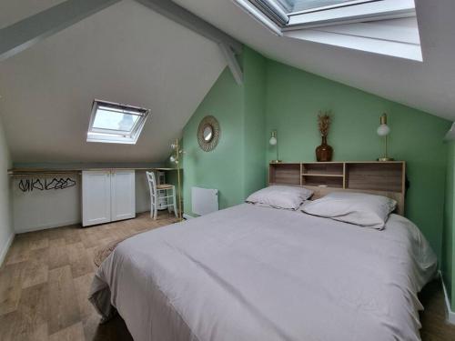 a bedroom with a large bed with green walls at Superbe duplex La Verrière chic, cosy et spacieux in Saumur