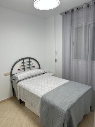 une chambre avec un lit dans une pièce blanche dans l'établissement San Juan de los Terreros Mª S, à San Juan de los Terreros