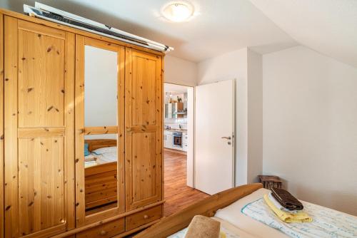 a bedroom with a large wooden cabinet and a bed at Schwalbenhof Dreßler und Duss für 2 Personen in Bad Herrenalb