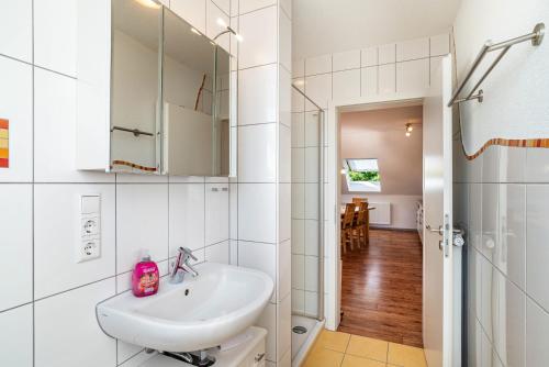 Baño blanco con lavabo y espejo en Schwalbenhof Dreßler und Duss für 4 Personen, en Bad Herrenalb