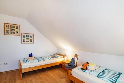 two twin beds in a attic room with white walls at Schwalbenhof Dreßler und Duss für 4 Personen in Bad Herrenalb