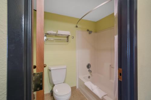 een badkamer met een wit toilet en een douche bij Americas Best Value Sandman Inn in La Grande