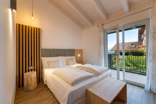 1 dormitorio con cama y ventana grande en Hotel Alt Spaur, en Spormaggiore