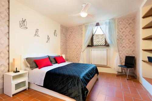 a bedroom with a bed with red pillows and a window at Central, Stylish with Terrace 6 Pax in Volterra