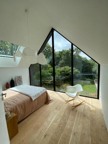 Les koumouls Grange noire في Gouesnou: غرفة نوم بسرير وكرسي أبيض