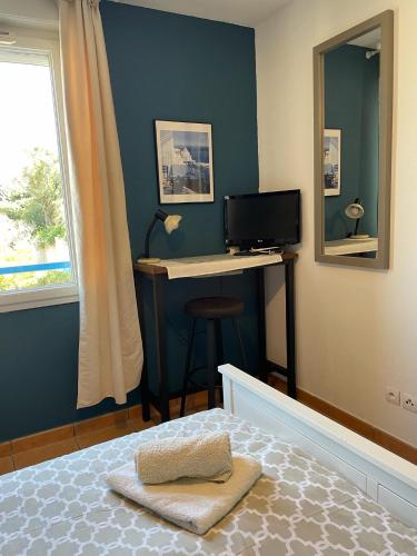 - une chambre avec un bureau et un lit avec un ordinateur dans l'établissement Joli appartement tout confort, à Hyères
