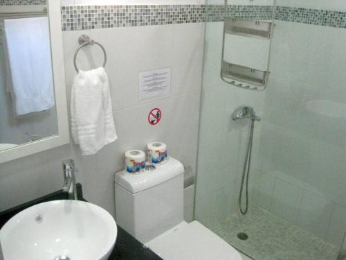Un baño con ducha, inodoro y lavabo. en Villa Palmas Doradas, en Cabarete