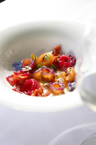 una ciotola bianca piena di pomodori e altre verdure di Mango Luxury Resorts a Sarandë