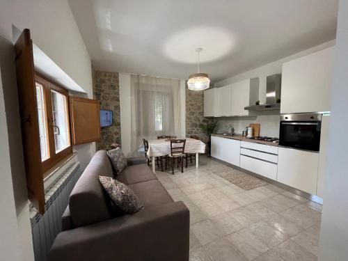 a living room and kitchen with a couch and a table at Casa Nella in Passignano sul Trasimeno