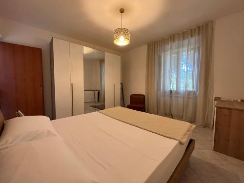 a bedroom with a large white bed and a window at Casa Nella in Passignano sul Trasimeno