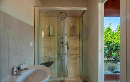 ein Bad mit einer Glasdusche und einem Waschbecken in der Unterkunft Awesome Home In Montefiore Dellaso With Jacuzzi in Montefiore dellʼAso