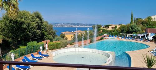 une vue sur une piscine avec des chaises et de l'eau dans l'établissement 2 pièces vue panoramique sur mer et baie de Cannes, à Théoule-sur-Mer