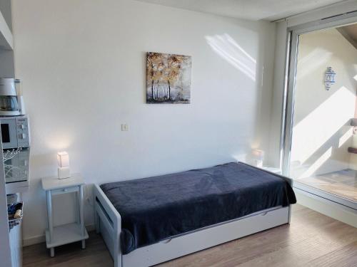 una piccola camera da letto con un letto e una finestra di BRITANNIA - Studio tout équipé, Vue mer - U95 a Carnac