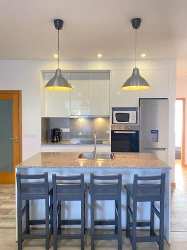 a kitchen with a island with chairs and a counter top at Apartamento em braga in Braga