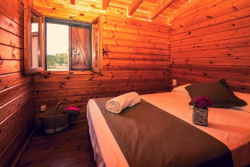 1 dormitorio con 1 cama en una cabaña de madera en Ecològic Vinyols Camp, en Vinyols i els Arcs