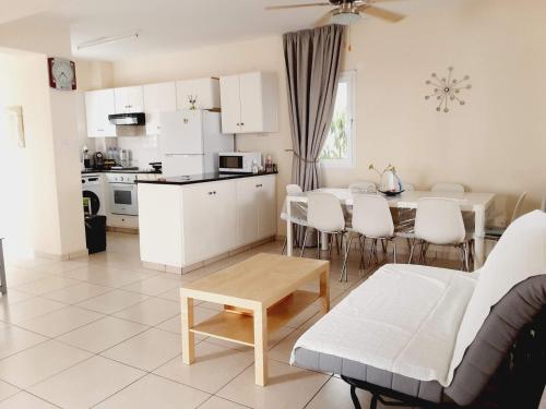 ein Wohnzimmer und eine Küche mit einem Tisch und einem Sofa in der Unterkunft Efterpis12 St. House in Paralimni