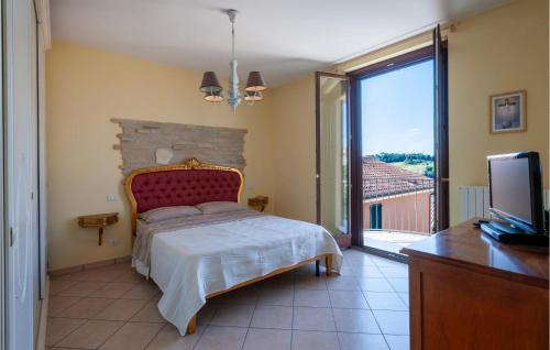 1 dormitorio con 1 cama, TV y balcón en 2 Bedroom Awesome Home In Potenza Picena, en Potenza Picena