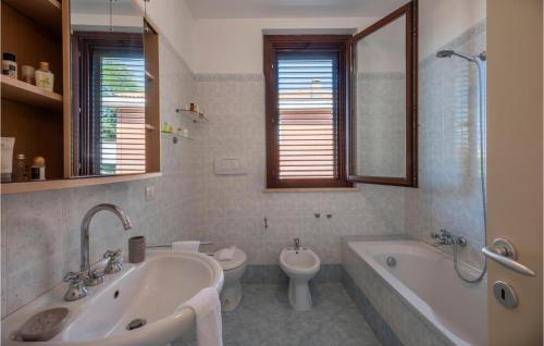 y baño con bañera, aseo y lavamanos. en 2 Bedroom Awesome Home In Potenza Picena, en Potenza Picena