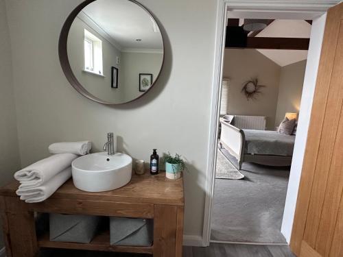 a bathroom with a sink and a mirror at White House Farm - Beautiful Self Contained Courtyard Rooms in Whitby
