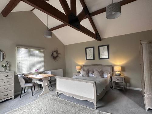 1 dormitorio con cama, escritorio y mesa en White House Farm - Beautiful Self Contained Courtyard Rooms en Whitby