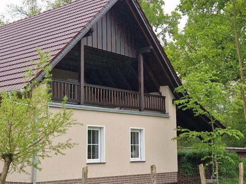 une maison avec un toit en gambrel et un balcon dans l'établissement Ferienwohnung Spreewaldglück, à Burg