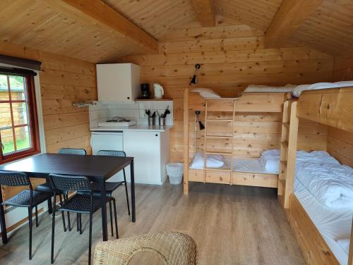 a kitchen and dining room with a dining table in a log cabin at Halland Camping in Berkåk