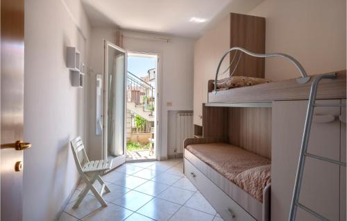 ein kleines Zimmer mit einem Etagenbett und einem Stuhl in der Unterkunft Nice Home In Porto Recanati With Wifi And 2 Bedrooms in Porto Recanati